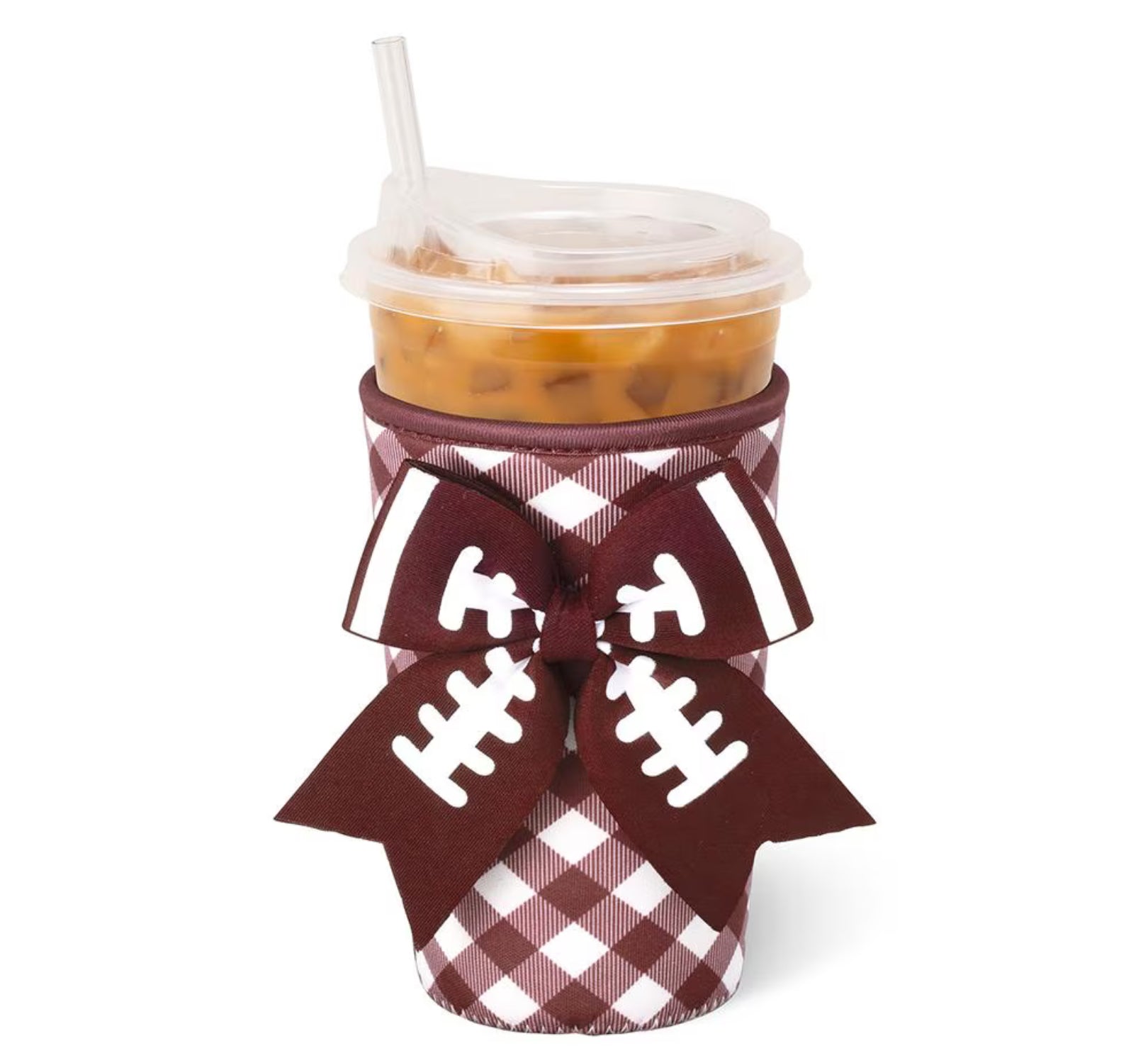 A clear plastic insulated travel tumbler cup with a lid and straw, wrapped in a maroon and white gingham pattern sleeve decorated with a large football-shaped ribbon bow featuring white laces