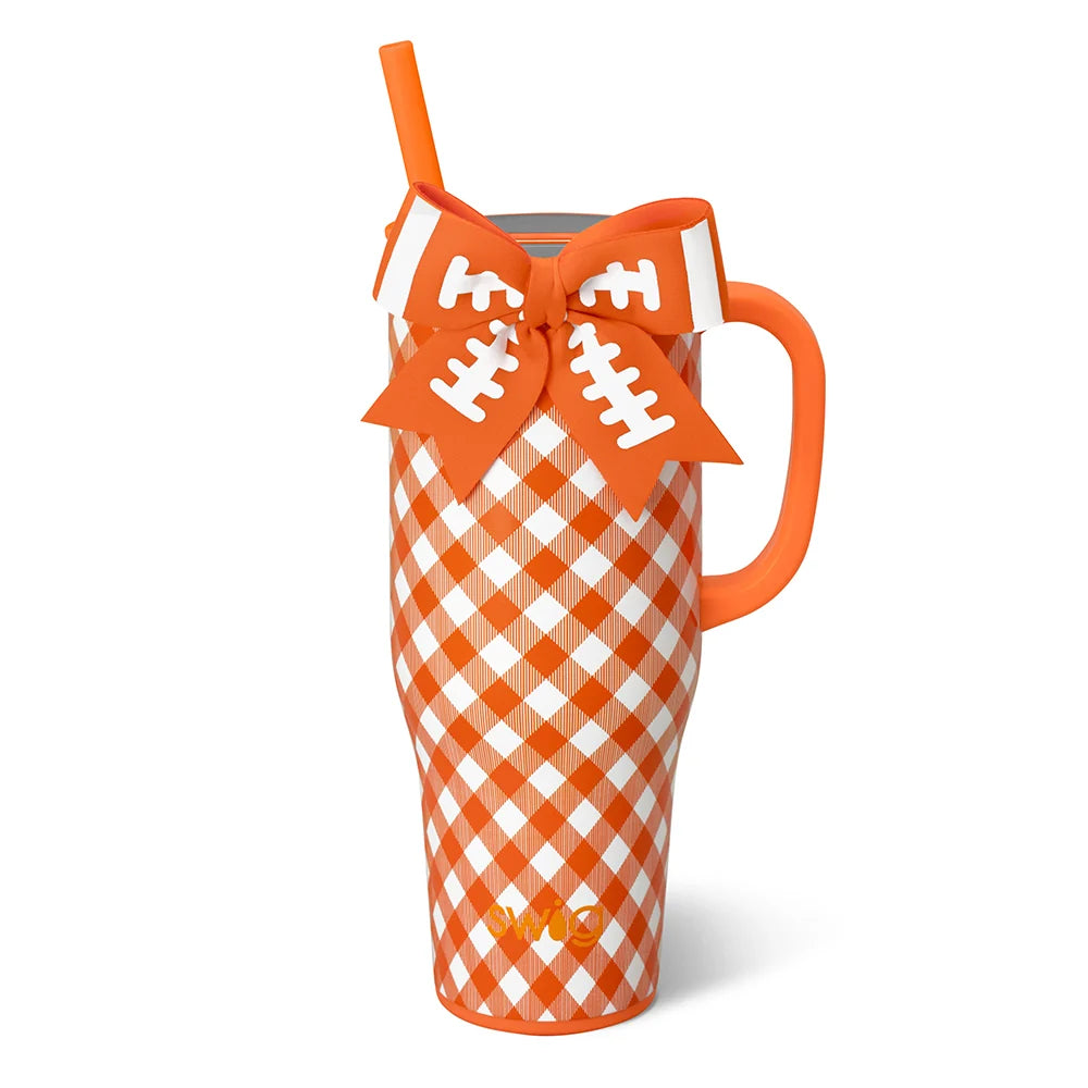 An orange and white gingham patterned handled tumbler with a matching orange handle, a white straw, and a decorative bow on the handle featuring football lace details.