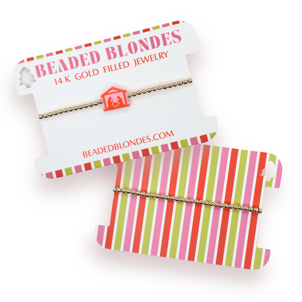 Beaded Blondes jewelry with a nativity charm on a striped card.