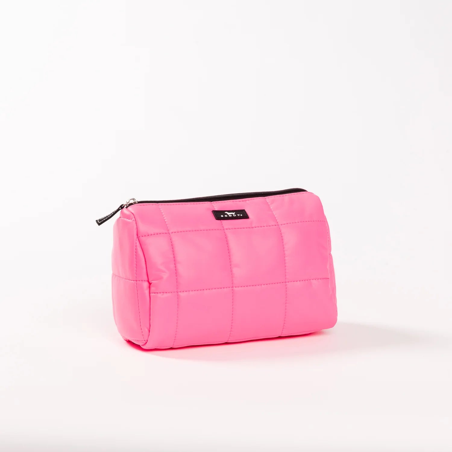 A bright pink quilted cosmetic pouch with a black zipper and a small black brand label, photographed on a clean white background.