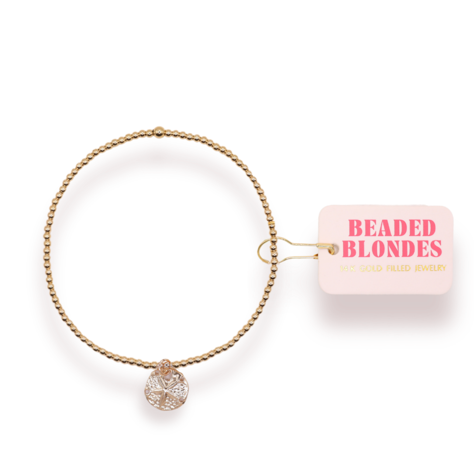 Gold bracelet with a sand dollar charm on a white background with 'Beaded Blondes' packaging.