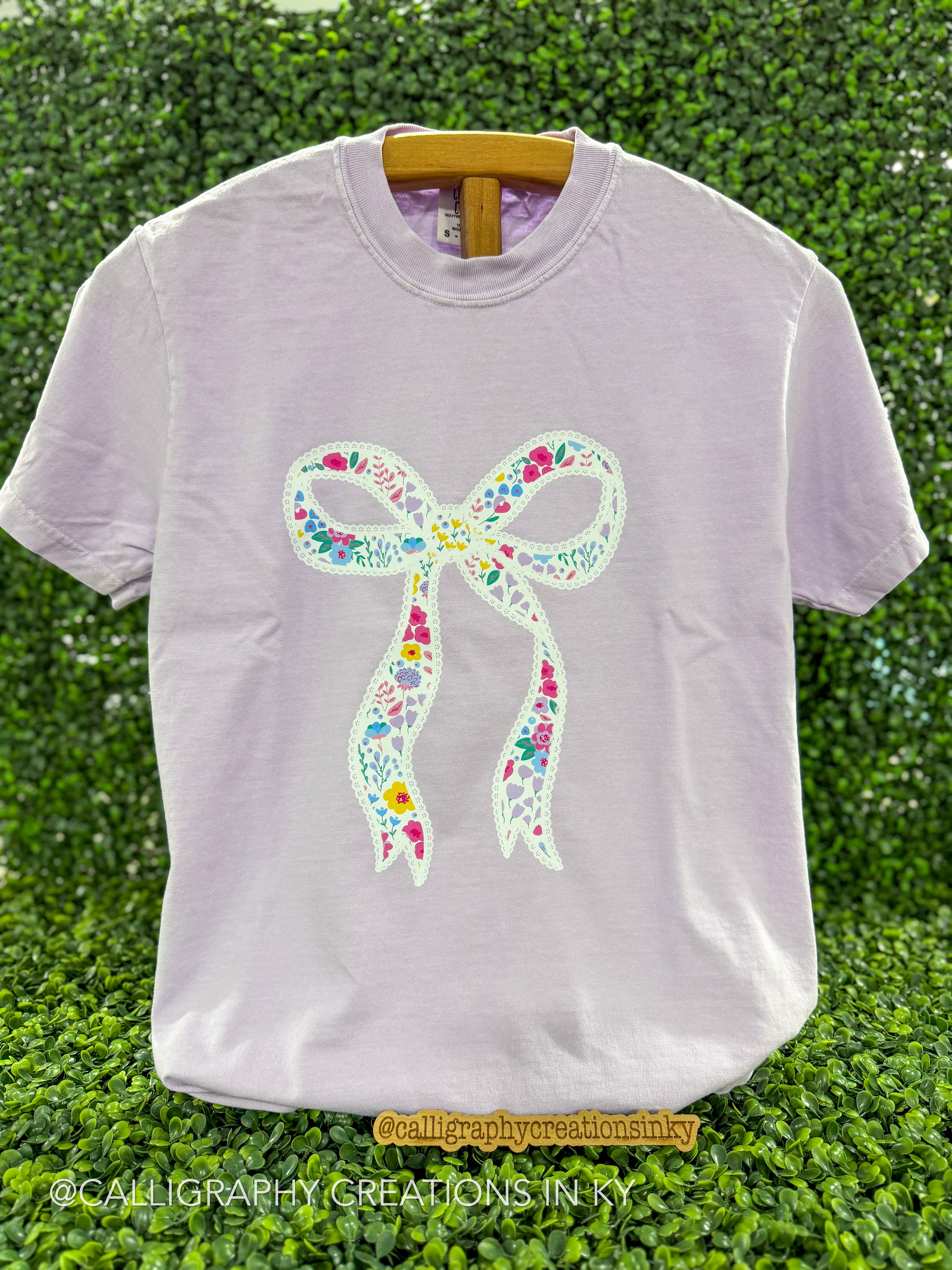 Orchid colored tee with a lace bow design