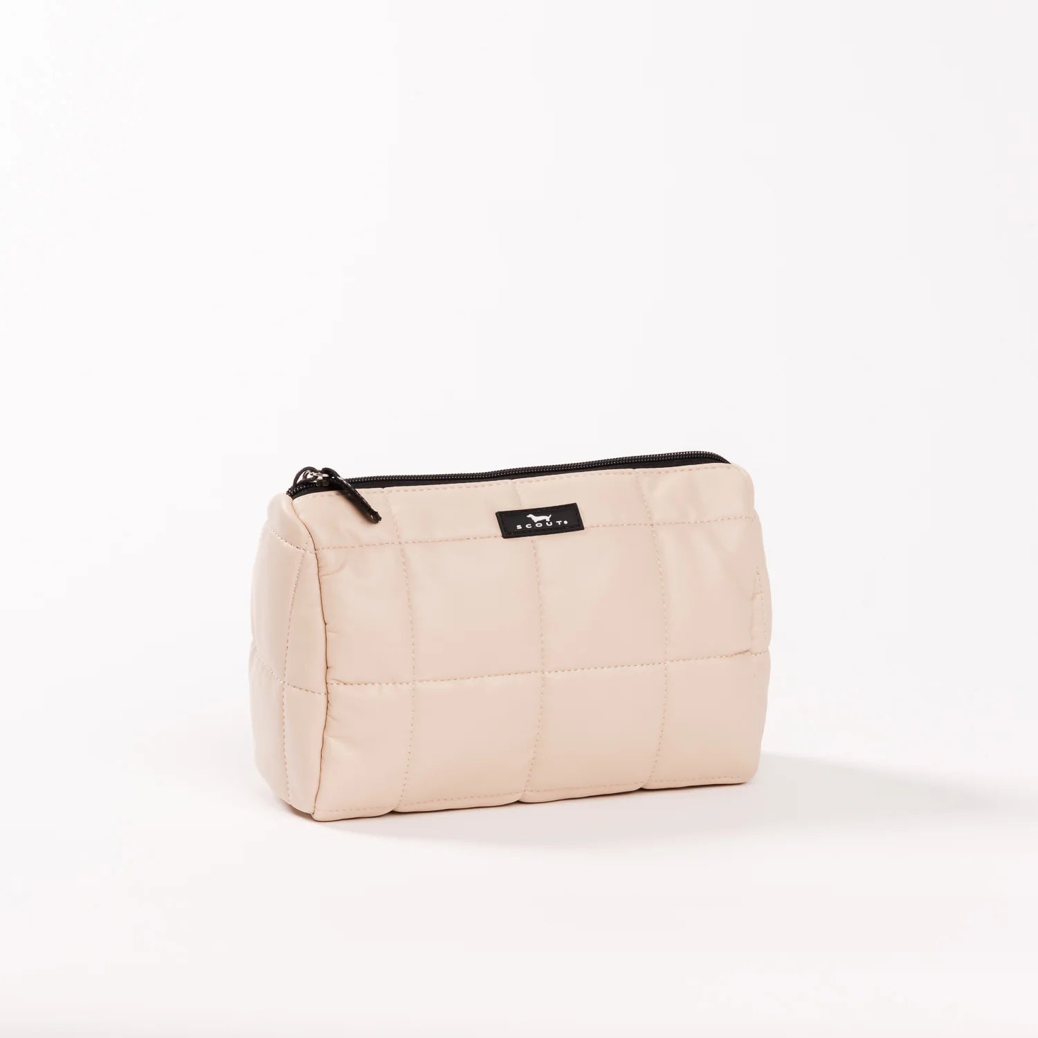 A light beige quilted cosmetic pouch with a black zipper and a small black brand label reading 'COCO BAGS' on a plain white background.