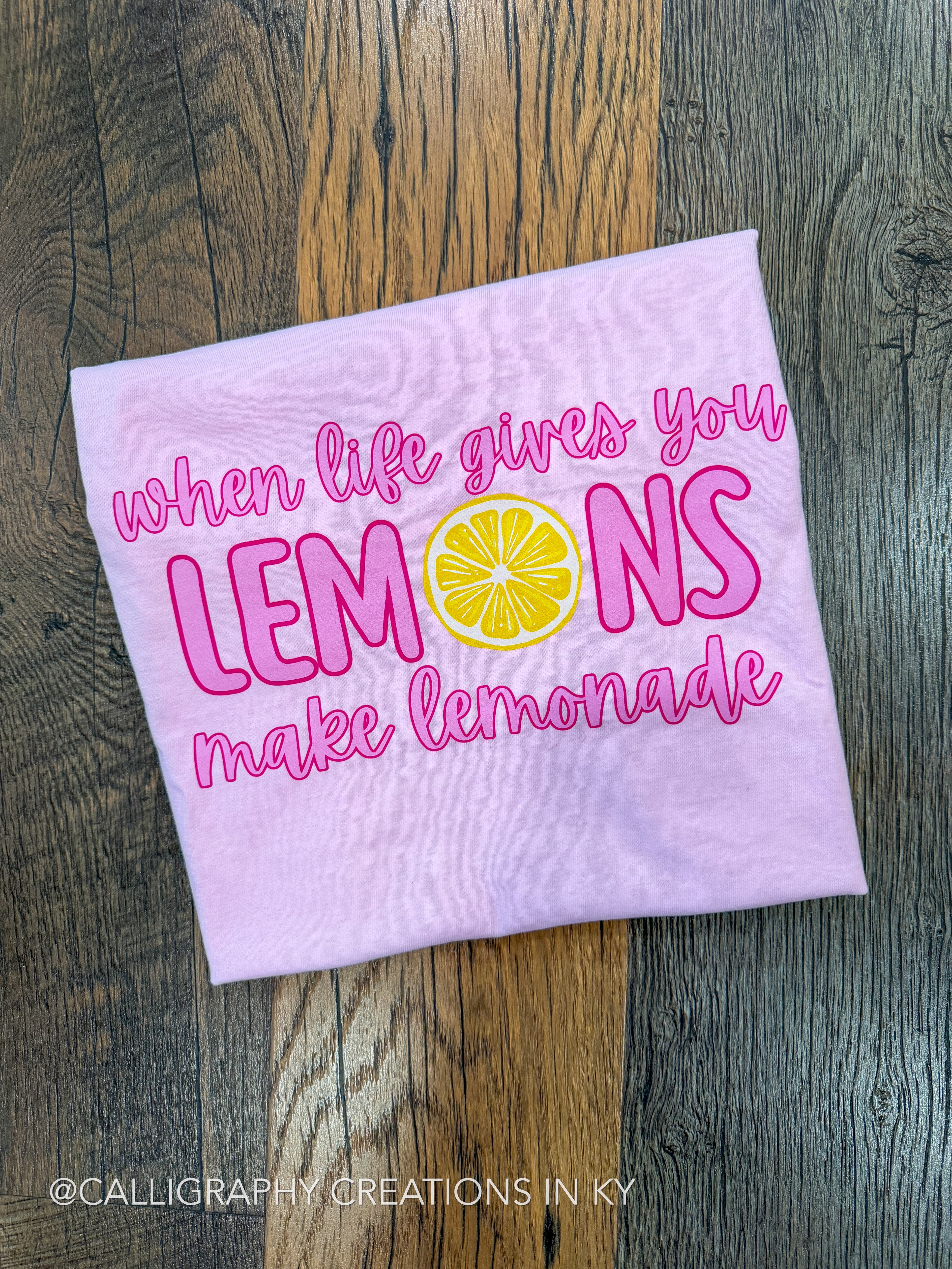 Pink tshirt with motivational quote on a wooden surface