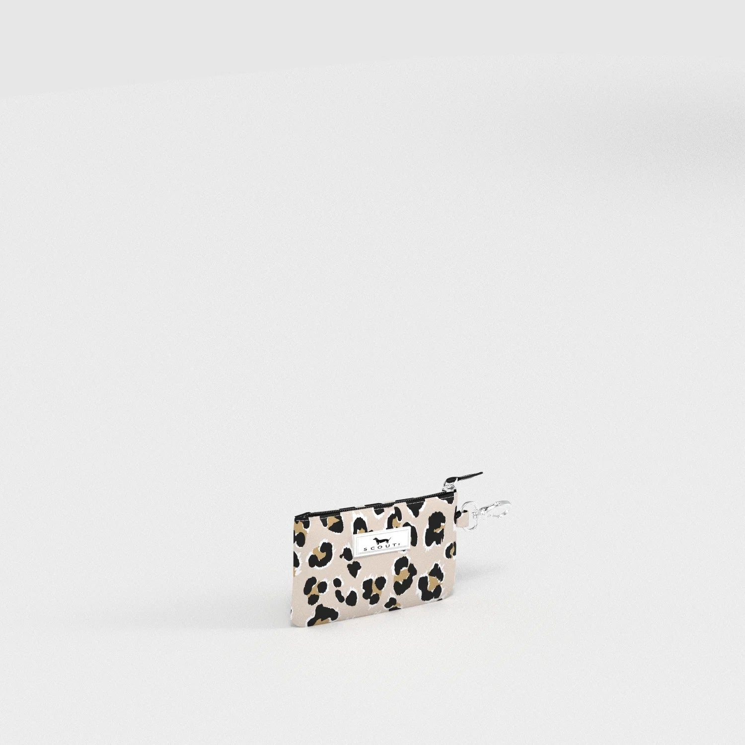 A small leopard-print zip pouch with a silver metal clasp and a white brand tag, photographed on a seamless white studio background.