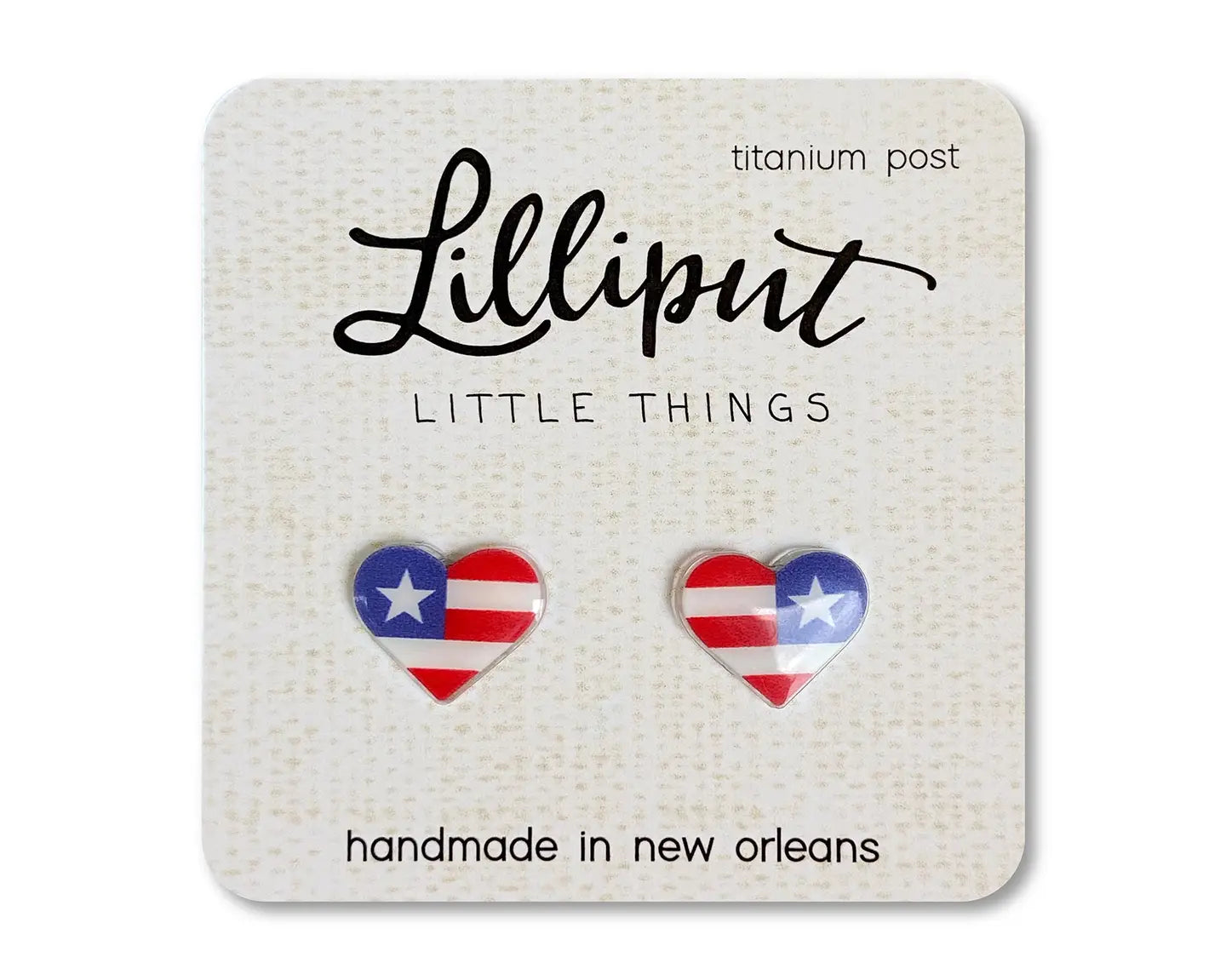 American flag heart shaped earrings on a beige card with white background 