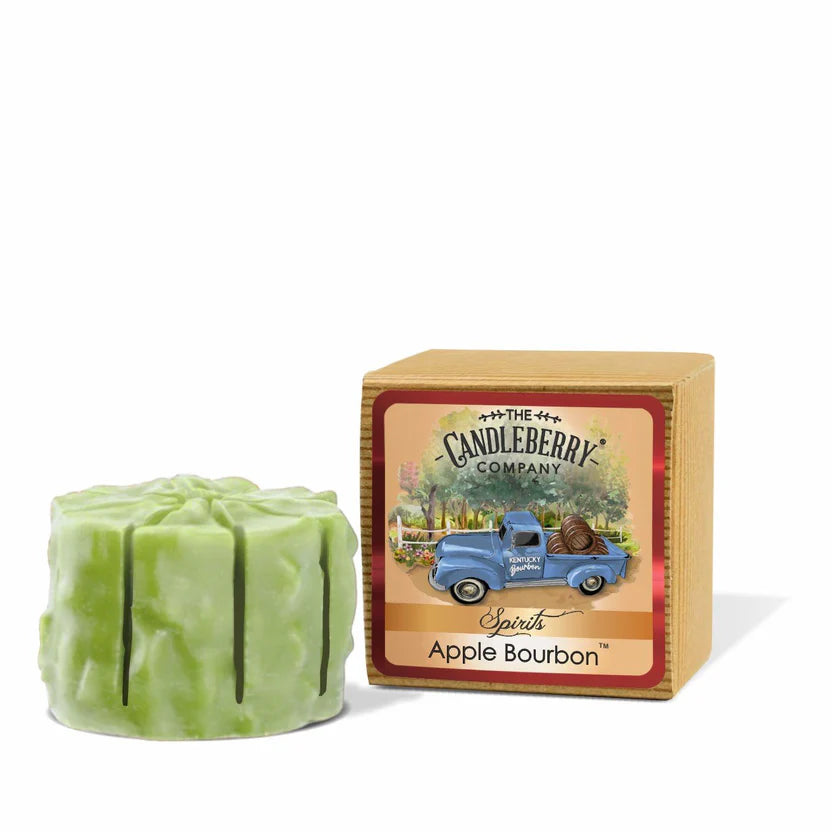 A green apple-shaped wax melt with a label indicating it is an Apple Bourbon scent. The product is packaged in a cardboard box with a vintage truck illustration.