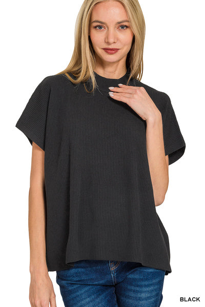 A woman wearing a black short-sleeve ribbed top with a mock neck and blue jeans, shown against a plain white background with a 'BLACK' label in the bottom right corner.