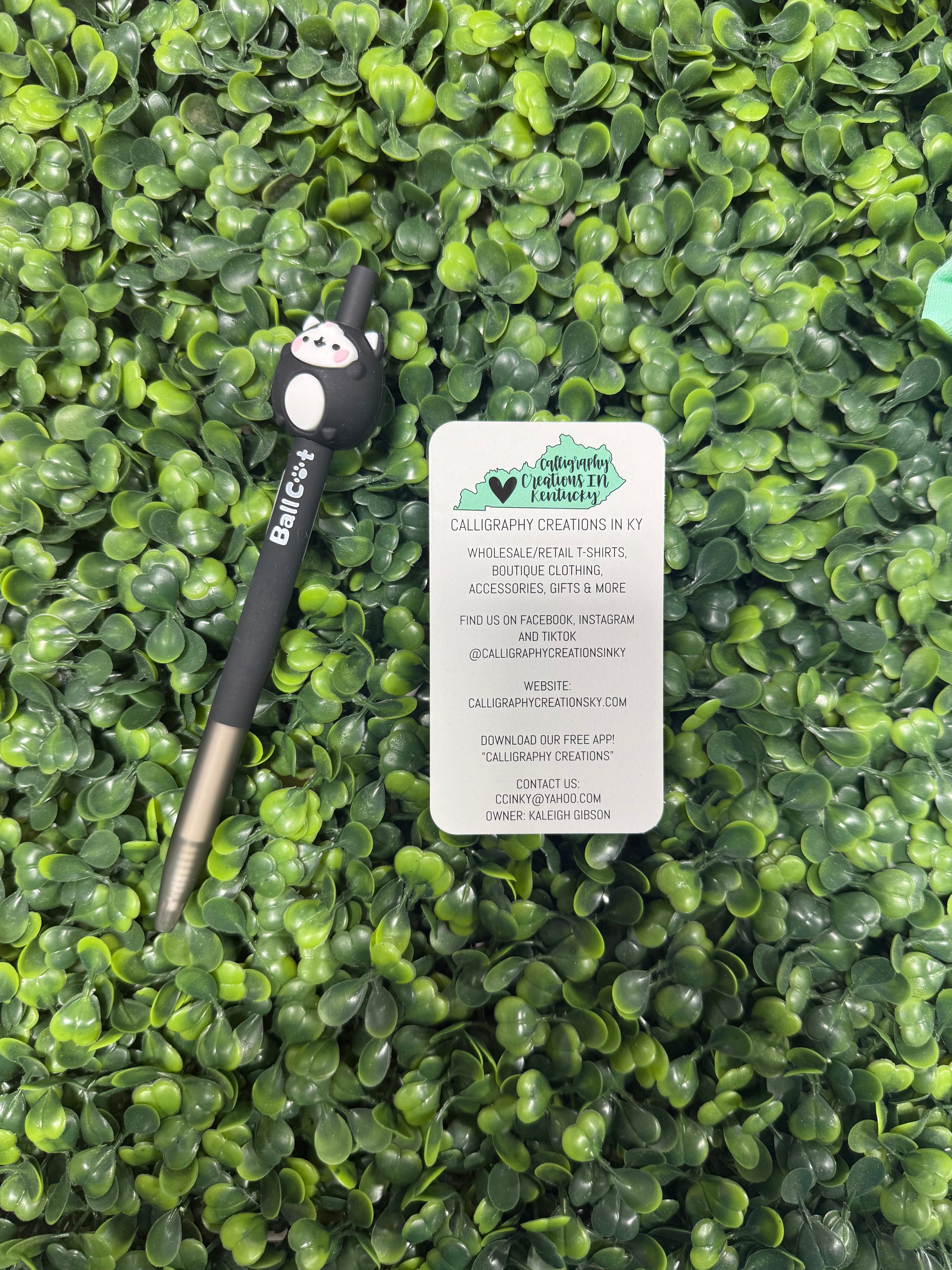 Black and white cat pen on a green leafy background