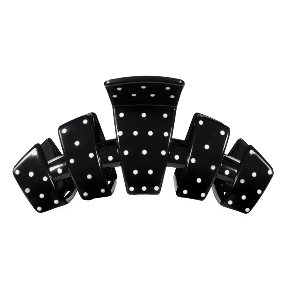 A glossy black hair claw clip with white polka dots, shown against a plain white background.