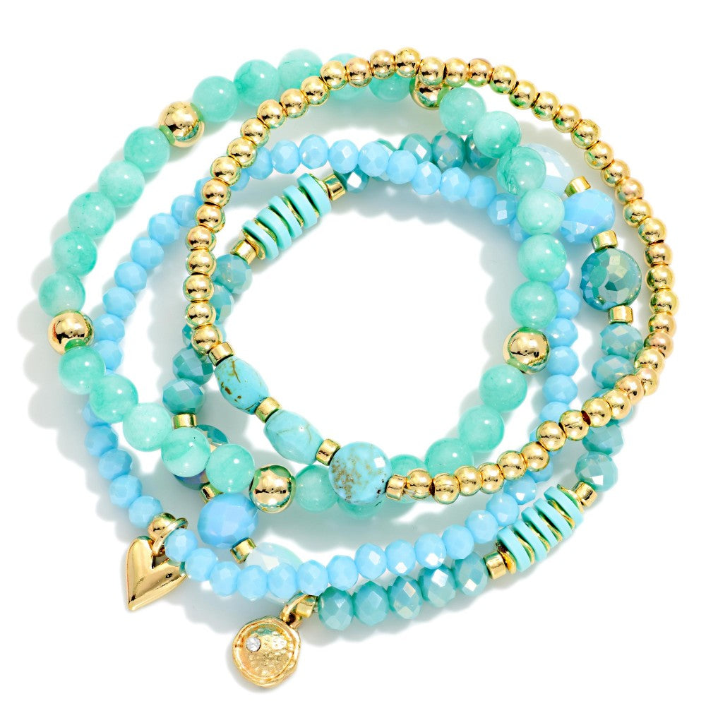 Stack of turquoise beaded bracelets with gold accents on a white background