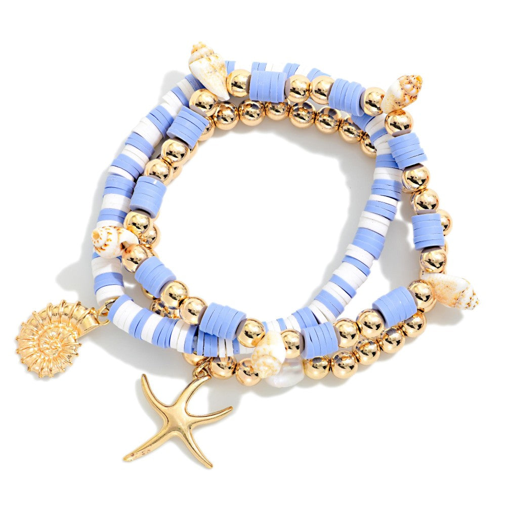 Set of blue and gold beaded bracelets with starfish charm on a white background