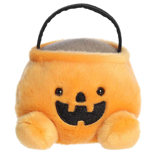 A plush pumpkin-shaped candy bucket with a black handle, featuring embroidered black eyes and a wide black smile on a soft orange-yellow background.