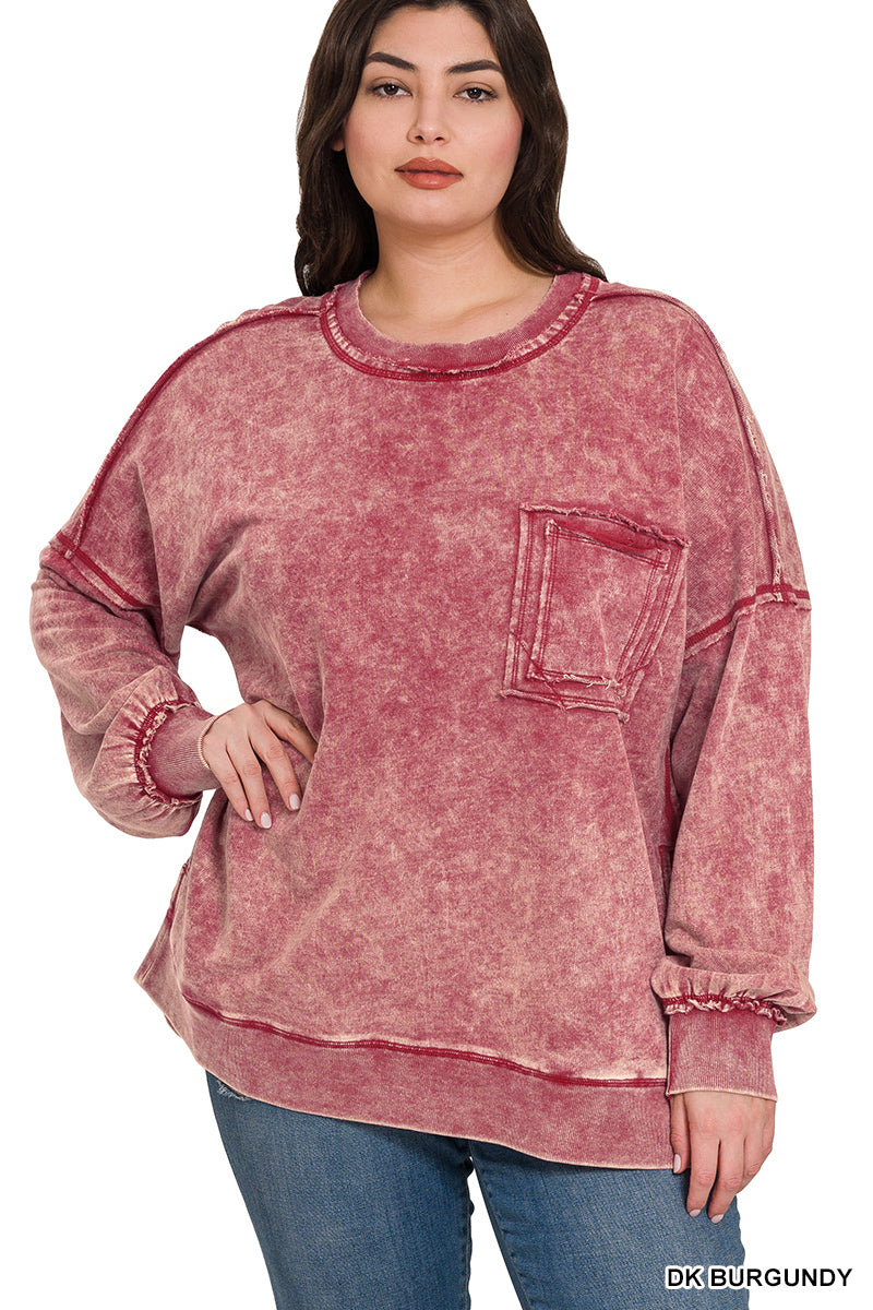 Woman wearing burgundy acid wash pullover with a pocket on the chest with blue jeans on a white background