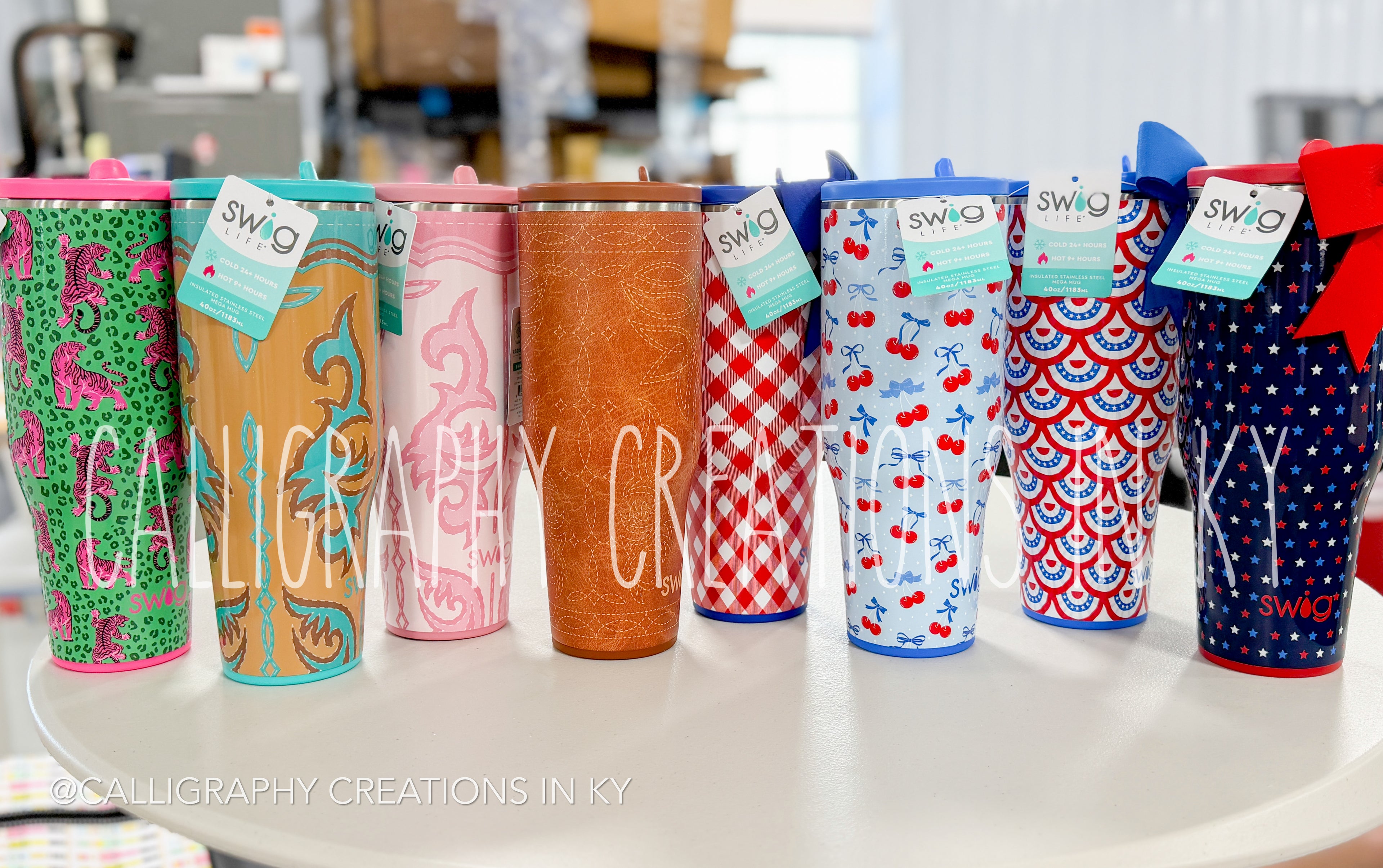 Colorful tumblers with various patterns on a white surface, featuring the brand 'Swig' at Calligraphy Creations In Kentucky