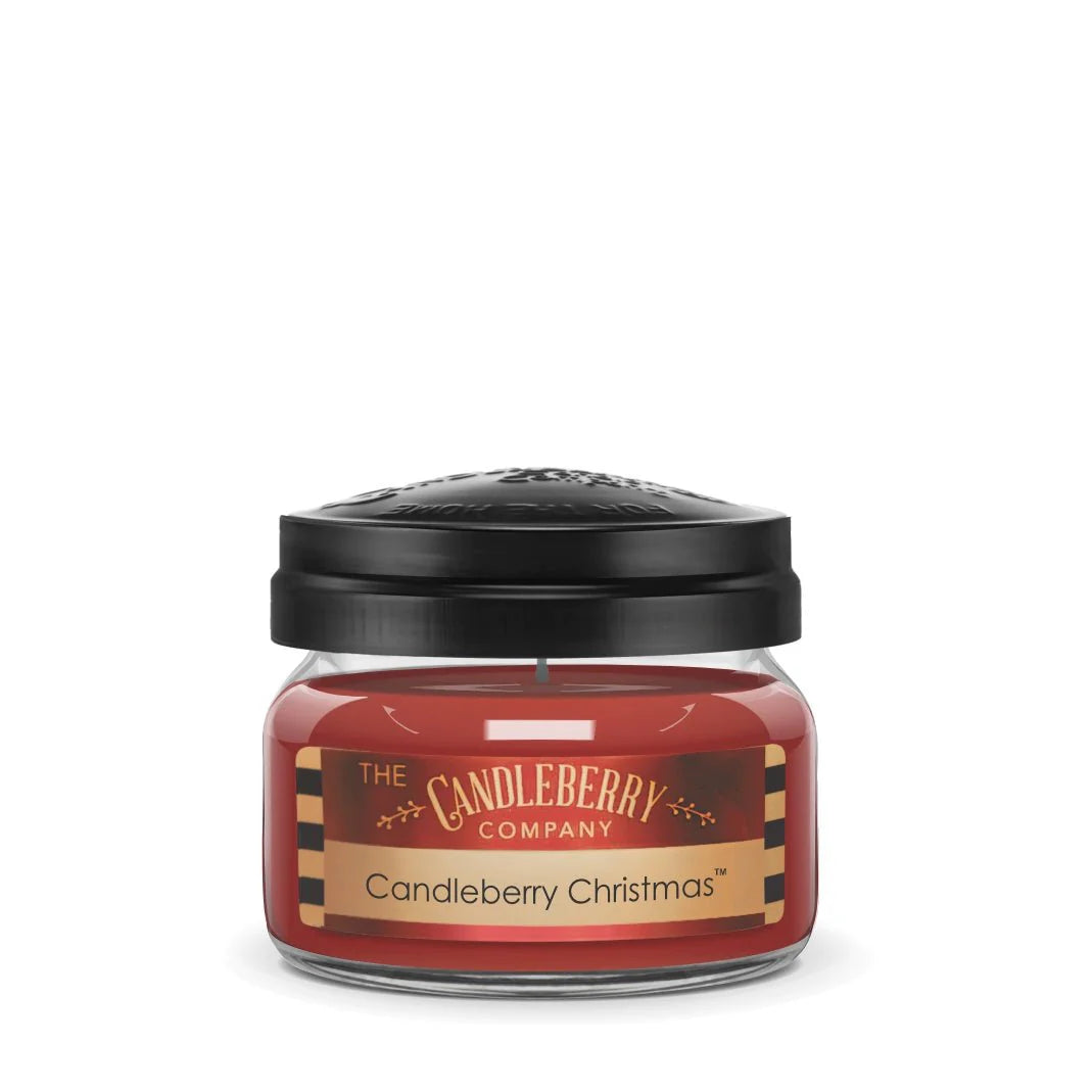A small red candle in a clear glass jar with a black lid, labeled 'The Candleberry Company Candleberry Christmas'.
