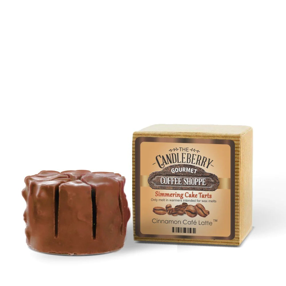 A wax melt designed to resemble a cinnamon café latte, placed in front of its packaging which reads 'Candleberry Gourmet Coffee Shoppe - Simmering Cake Tarts - Cinnamon Café Latte'.