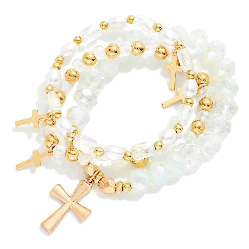 Three beaded clear and gold bracelets with cross charms. 