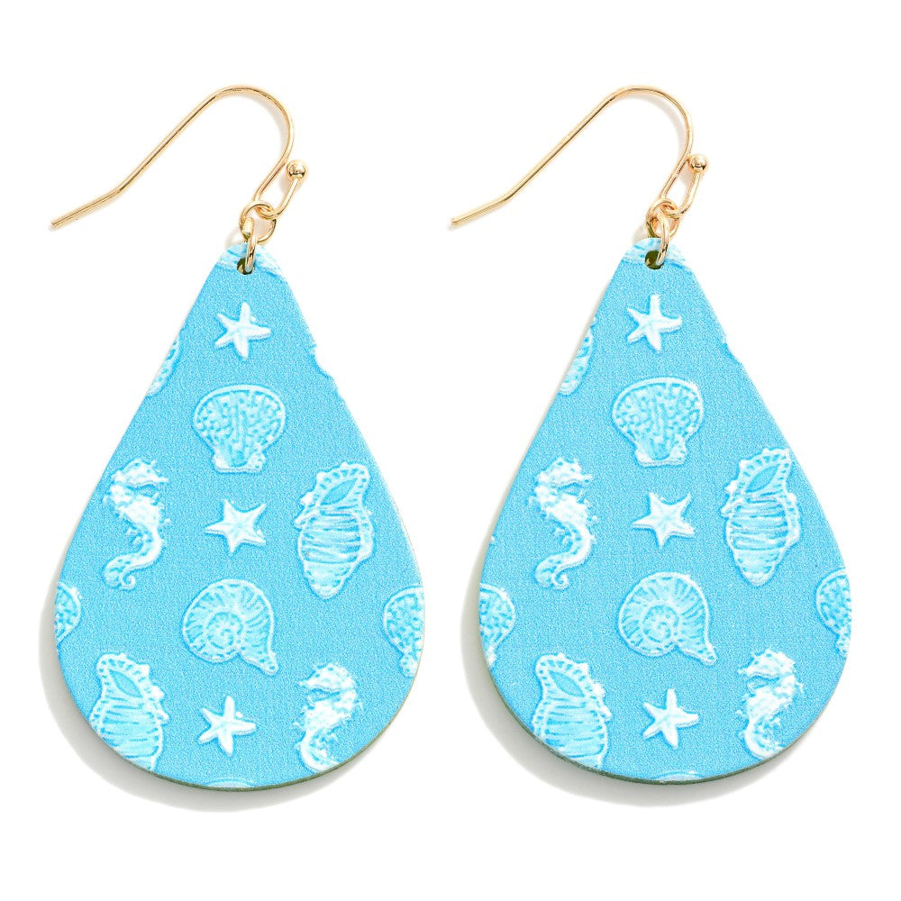 Blue teardrop earrings with seashells and seahorses printed on them