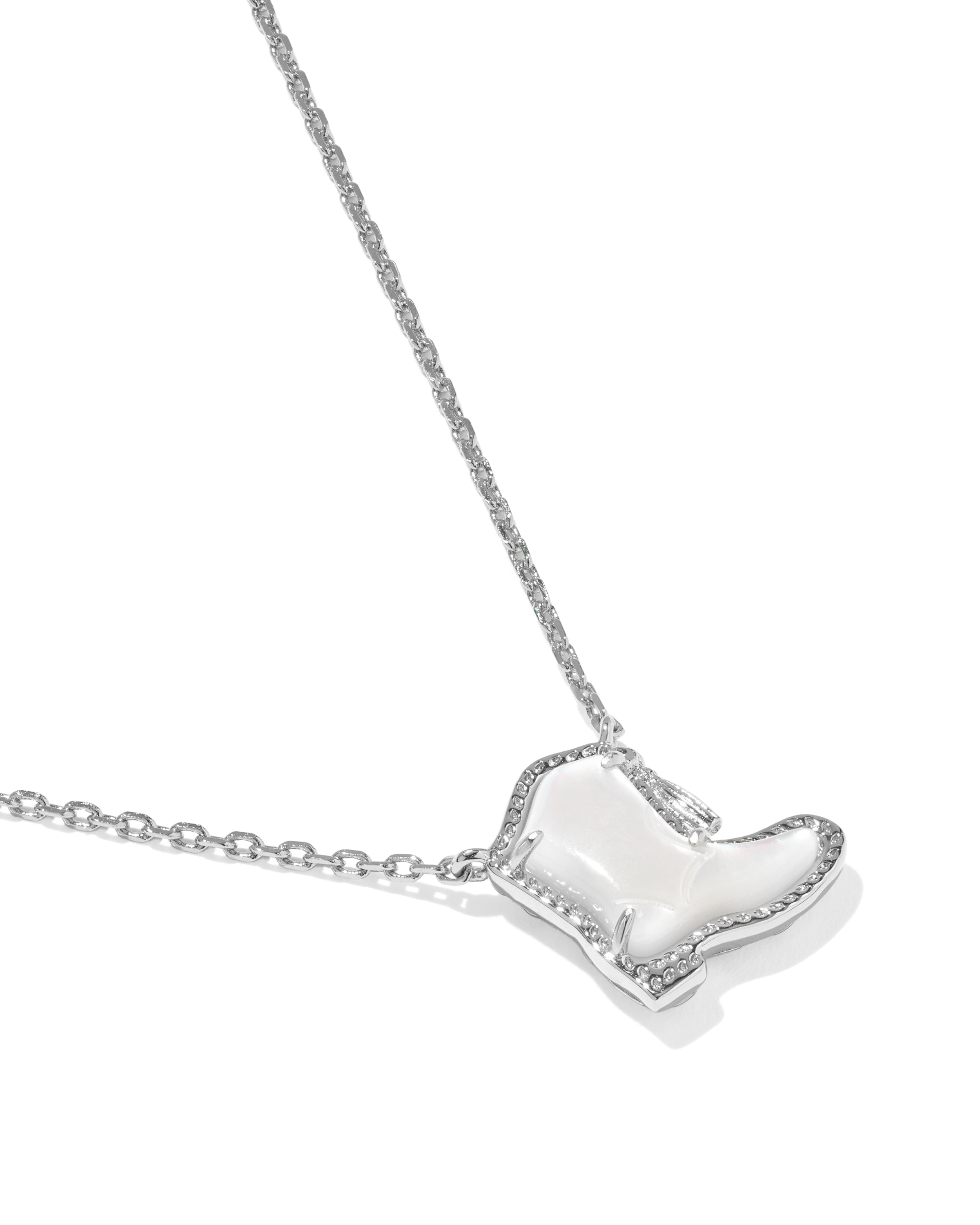 A silver-toned necklace featuring a boot-shaped pendant with a white inlay and small clear stones around the border, shown on a clean white background.