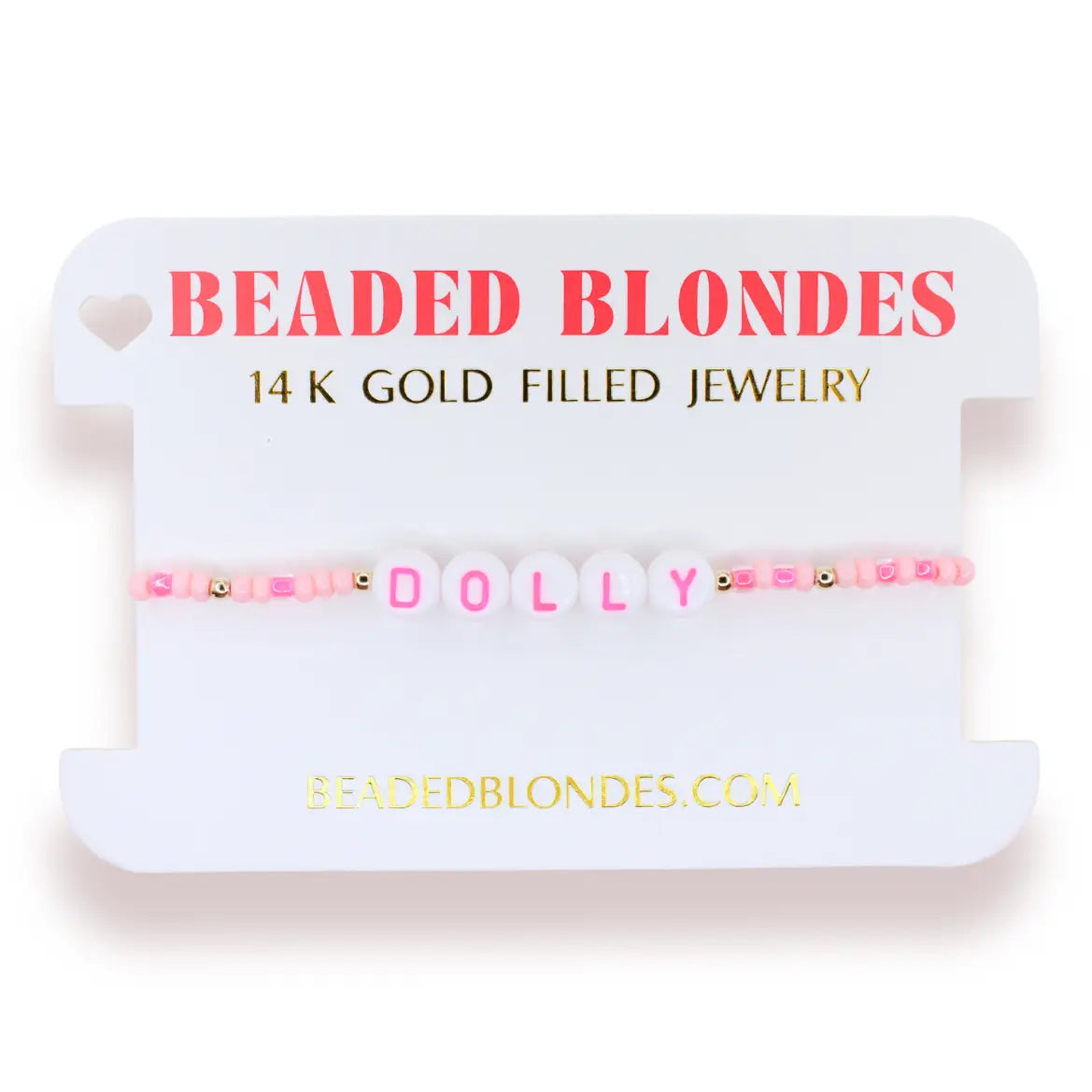 A pink beaded bracelet spelling 'DOLLY' with gold-filled beads, displayed on a white branded card that reads 'BEADED BLONDES 14 K GOLD FILLED JEWELRY'.