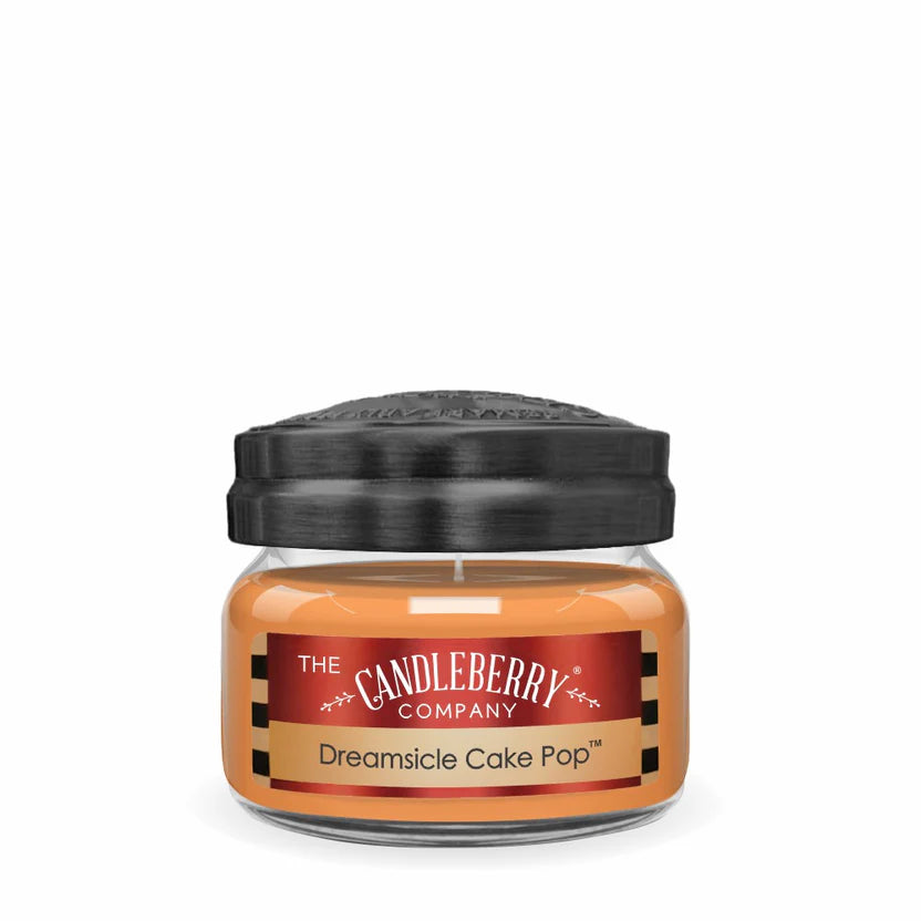 A small jar candle with a black lid, orange label reading 'Dreamsicle Cake Pop', produced by The Candleberry Company.
