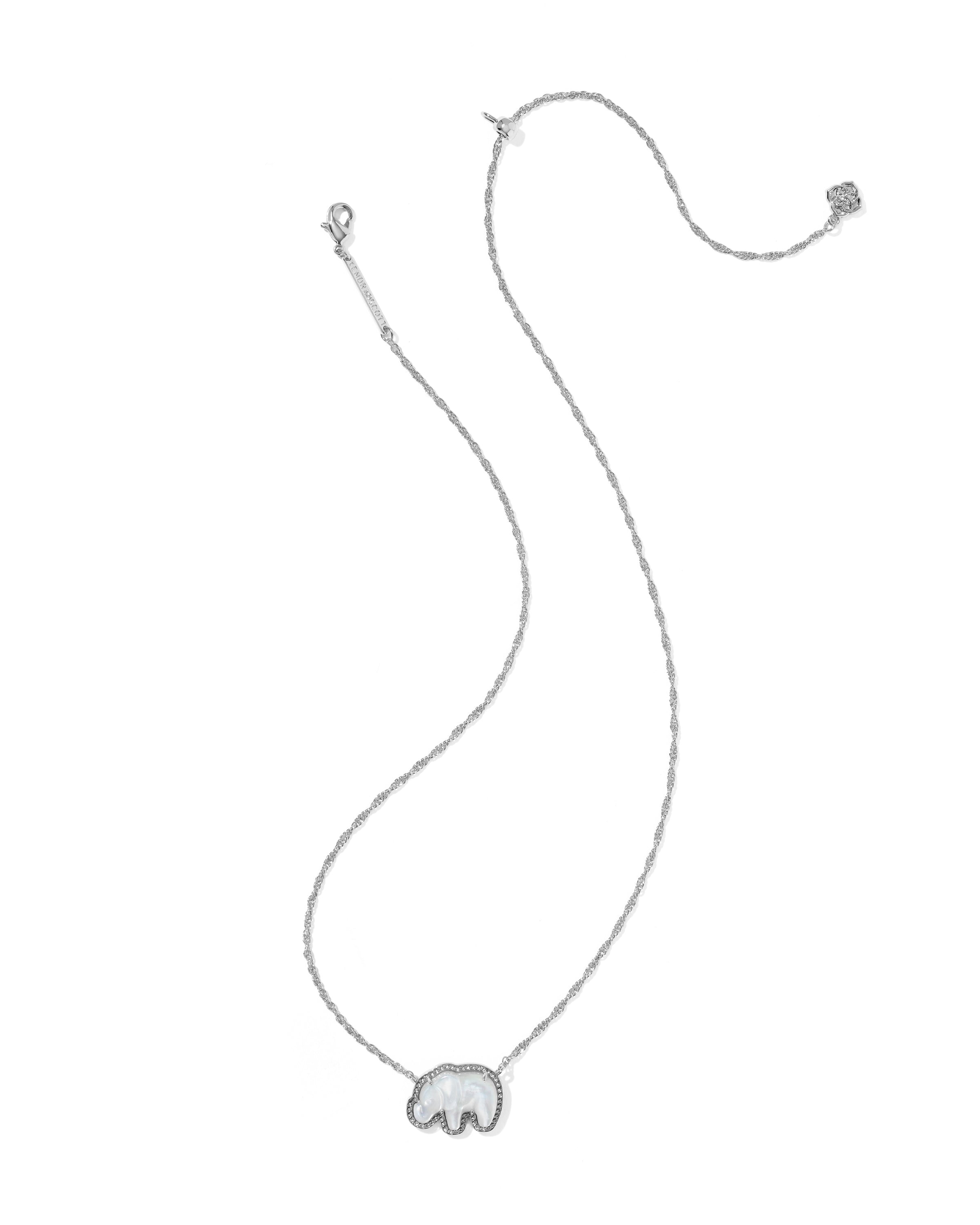 A delicate silver-toned necklace featuring a small elephant-shaped pendant, displayed on a solid white background.