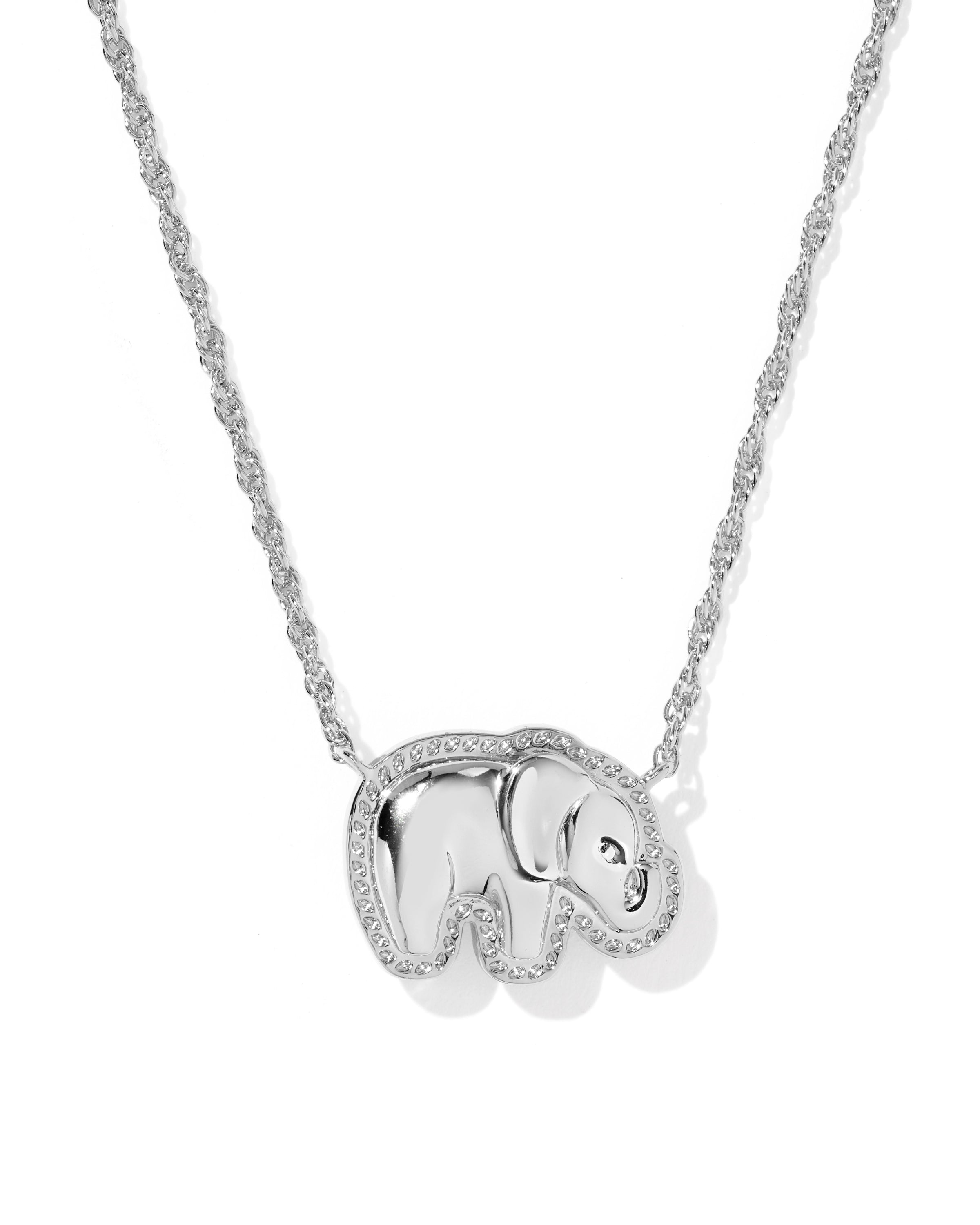 A silver-toned necklace featuring a small elephant pendant outlined with clear stones, suspended from a matching twisted chain on a white background.