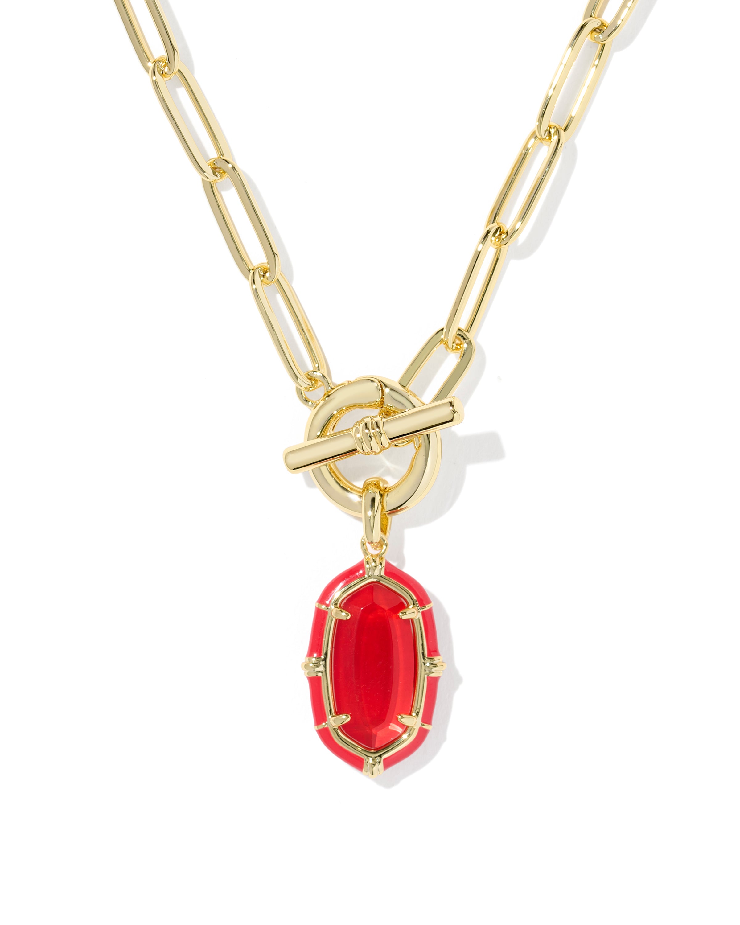 A gold paperclip chain necklace with a toggle clasp and a red oval pendant, shown on a plain white background.
