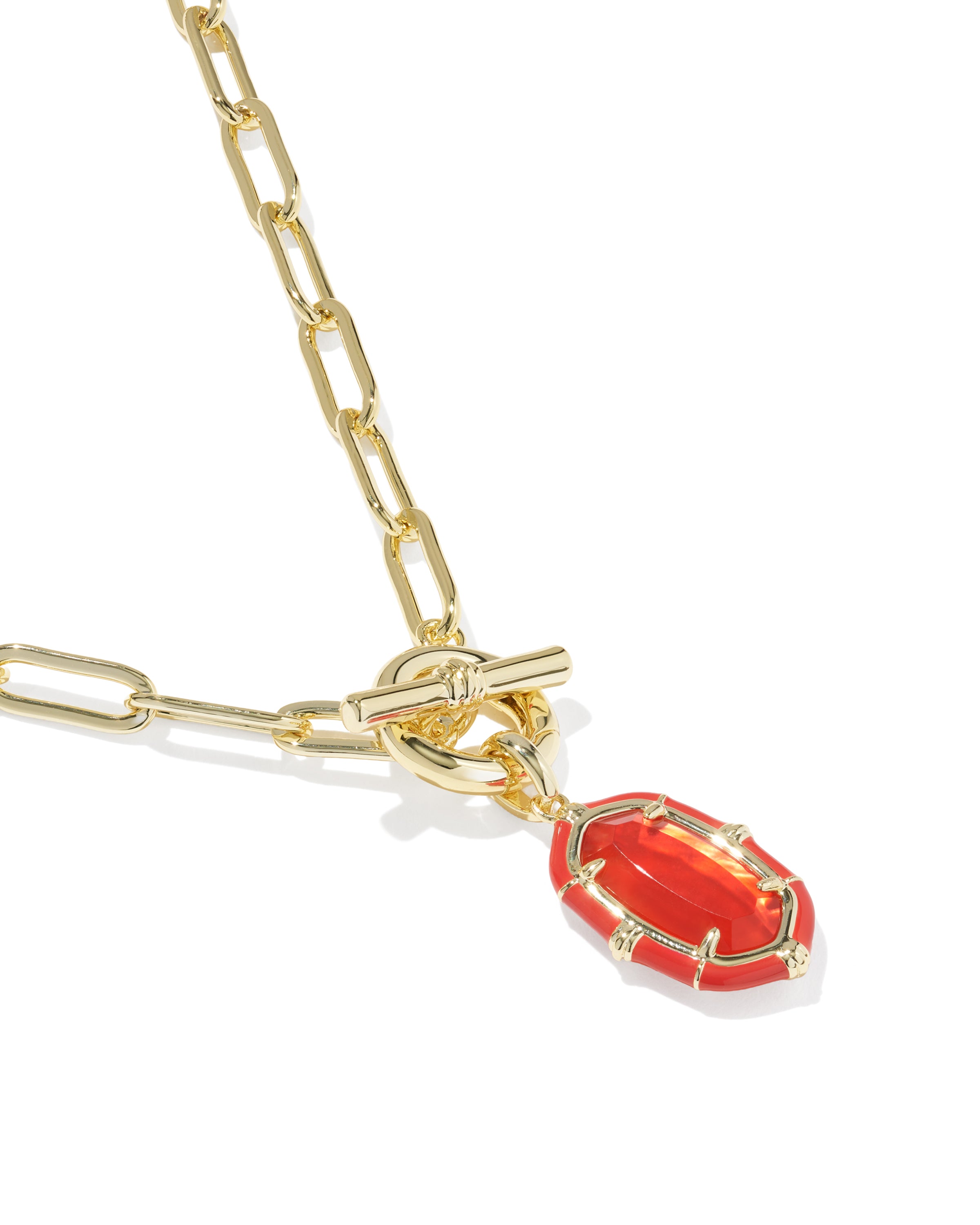 A gold paperclip chain necklace with a toggle clasp and a dangling red enamel pendant, shown on a clean white background.