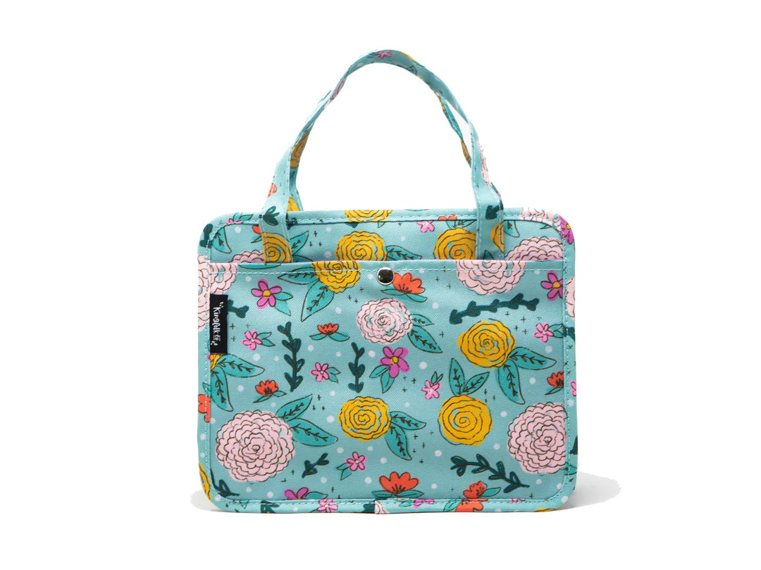 A turquoise tote bag with a colorful floral pattern featuring pink, yellow, and orange flowers with green leaves, shown against a plain white background.