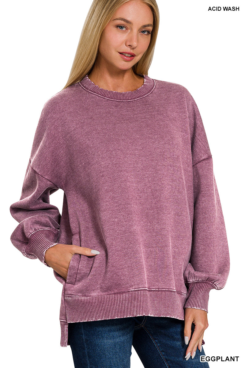 A woman wearing a long-sleeve crewneck sweatshirt in a heathered eggplant purple color, styled with blue jeans. The image has 'ACID WASH' text in the top right corner and 'EGGPLANT' text in the bottom right corner, set against a plain white background.