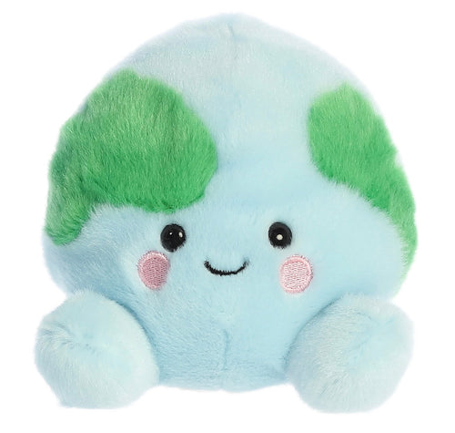 A cute, round, light blue plush toy with green leaf-like ears, embroidered black eyes and a smile, and pink cheek details, isolated on a white background.