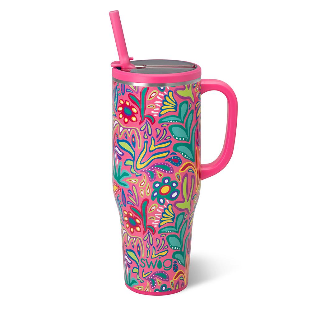 Colorful tumbler with floral pattern and pink handle on a white background