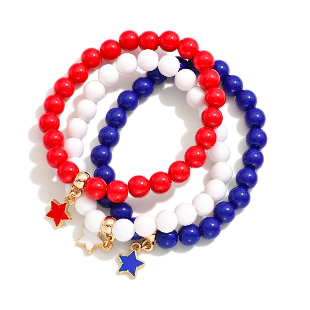 Three beaded bracelets with red, white, and blue beads and star charms on a white background