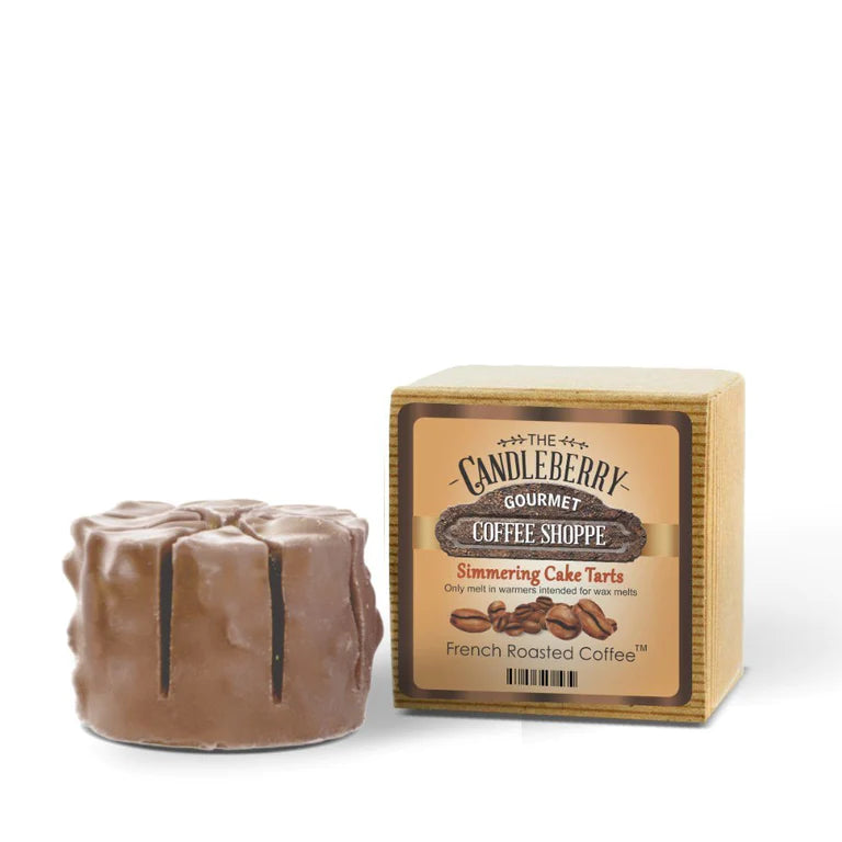 A wax melt designed to resemble a coffee tart, placed in front of its packaging which reads 'Candleberry Gourmet Coffee Shoppe French Roasted Coffee Simmering Cake Tarts'.