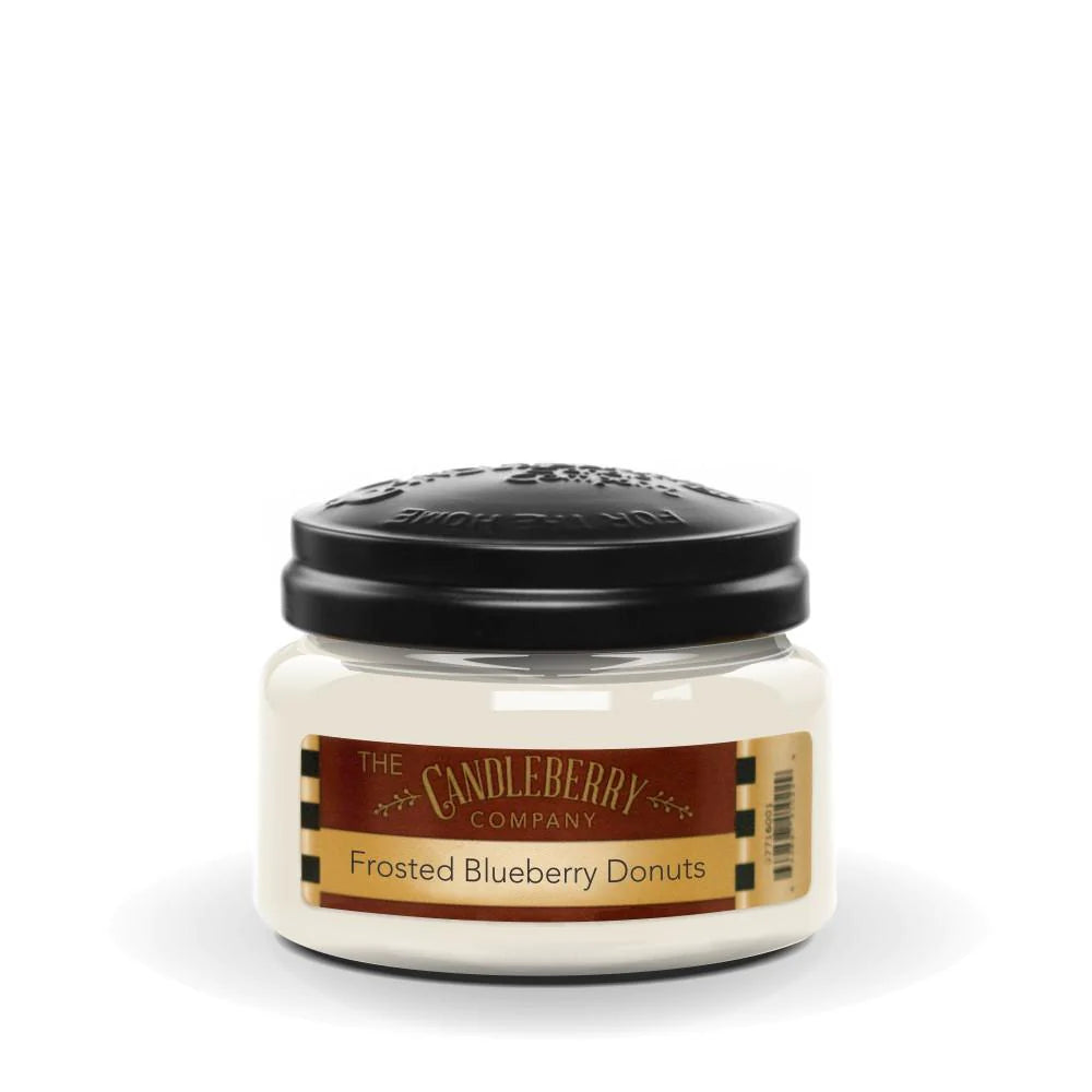 A small clear jar of Candleberry brand frosted blueberry donuts scented candle with a black lid on top.