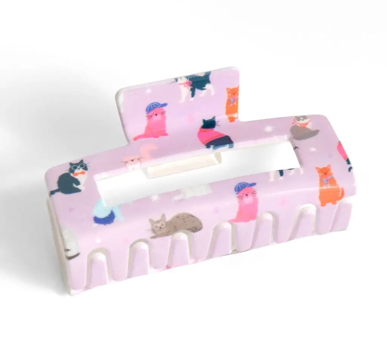 A pink hair claw clip decorated with a pattern of cute illustrated cats in various colors, shown on a clean white background.