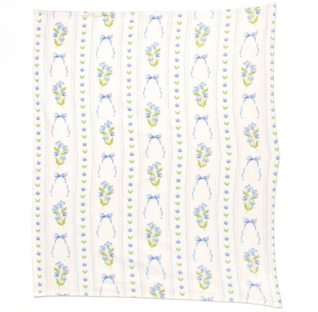 A square white fabric blanket featuring a vertical striped pattern with blue ribbon bows, small blue flowers, and green leaves.