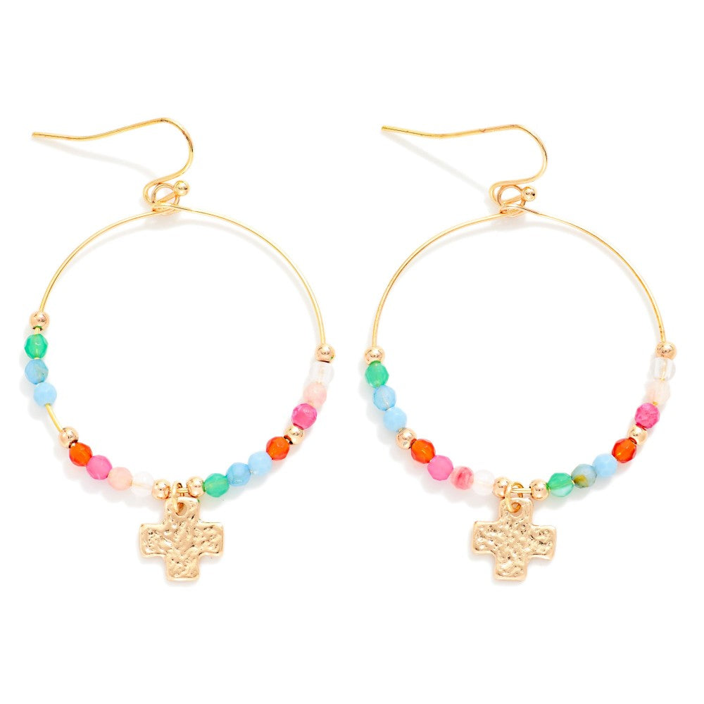 Gold hoop earrings with colorful beads and cross charms on a white background