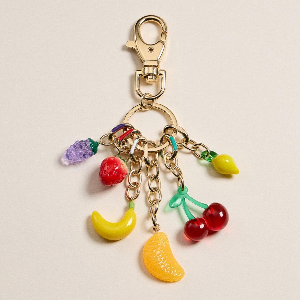 Colorful fruit-themed keychain on a beige background