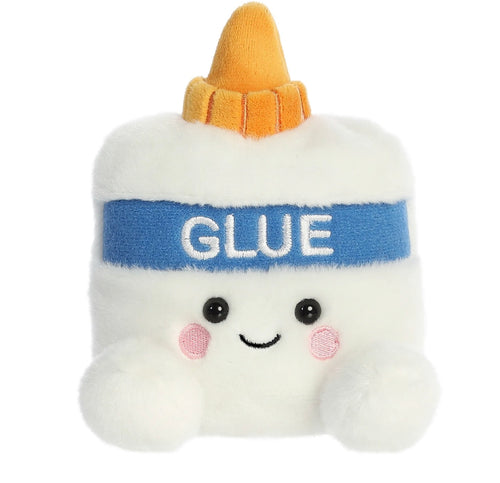 A cute, white plush toy shaped like a glue bottle, featuring a blue band with the word 'GLUE' in white, a yellow-orange pointed top, and a smiling face with pink cheeks.