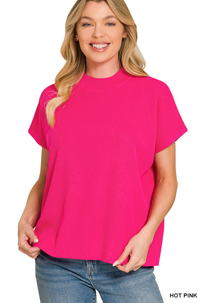 A woman wearing a bright hot pink short-sleeve ribbed knit top with blue jeans, shown against a plain white background with a 'HOT PINK' text label in the bottom right corner.