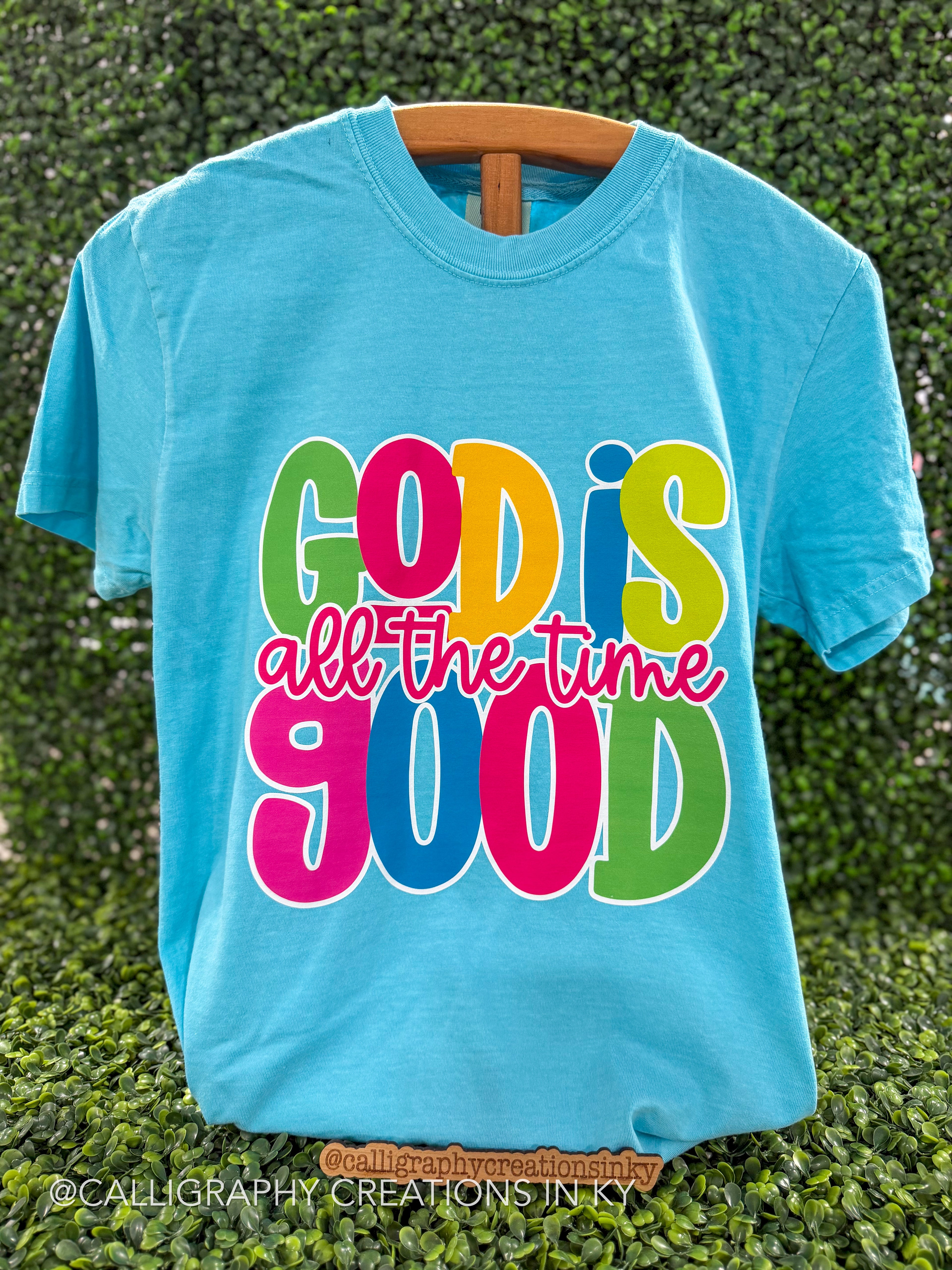 Blue colored tee with a design that says God is good all the time