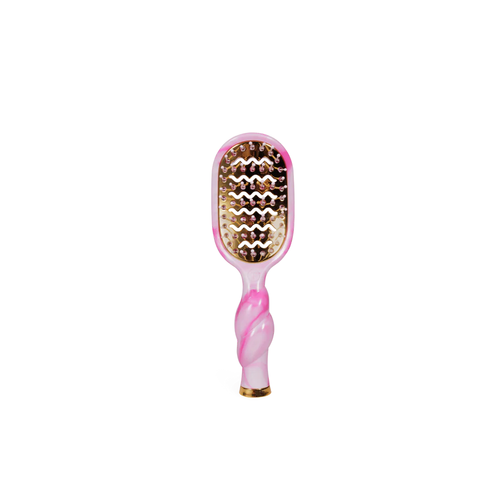Pink and gold hairbrush on a white background