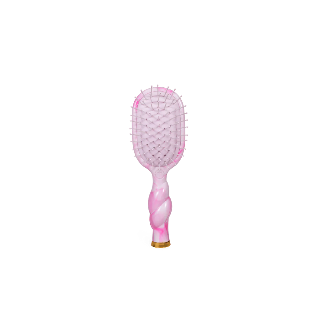 Pink and gold hairbrush on a white background
