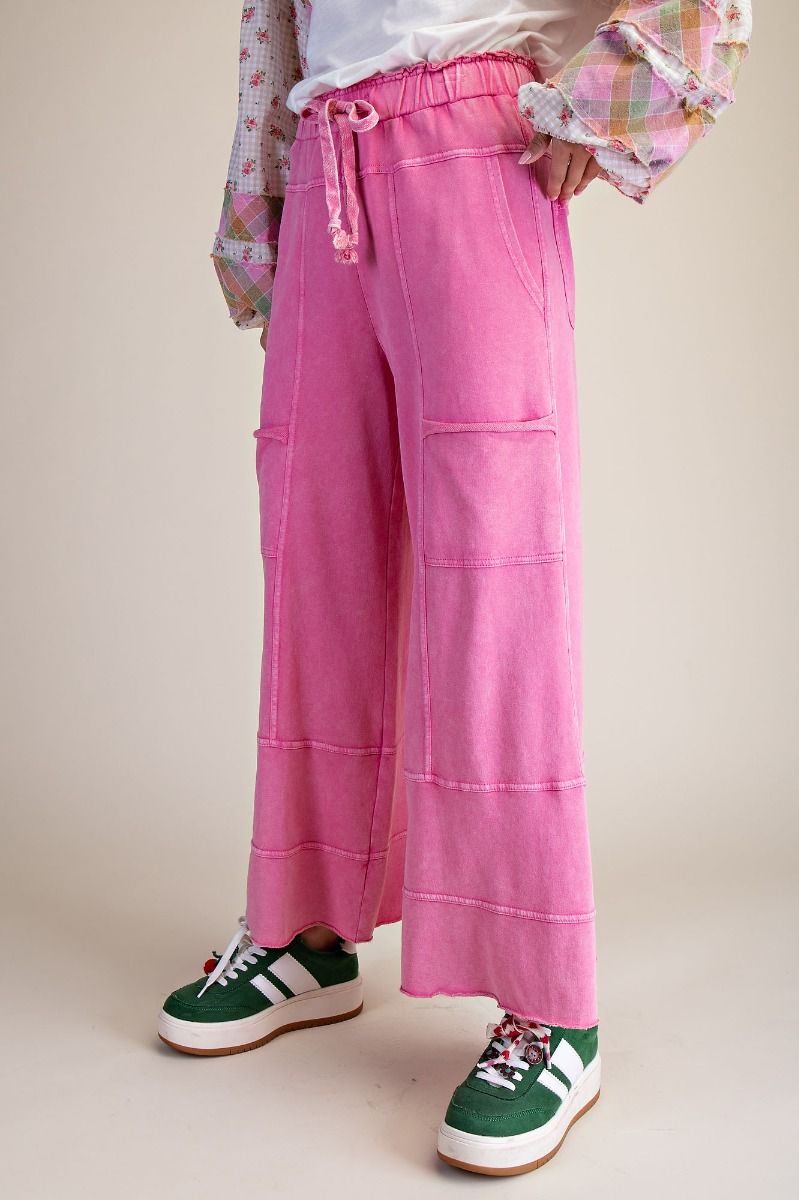 Person wearing pink pants with a plain background