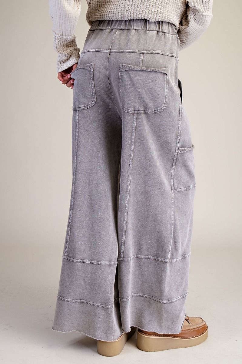 Person wearing light gray wide-leg pants on a plain background