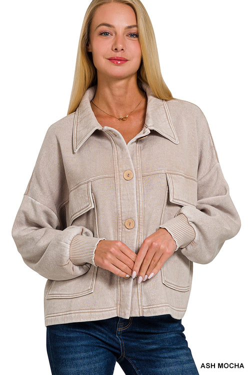 Woman wearing a light brown shacket on a white background.