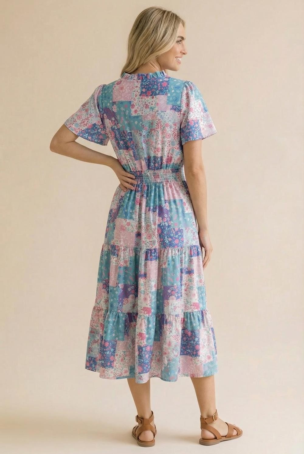 Woman wearing a colorful patchwork dress on a beige background
